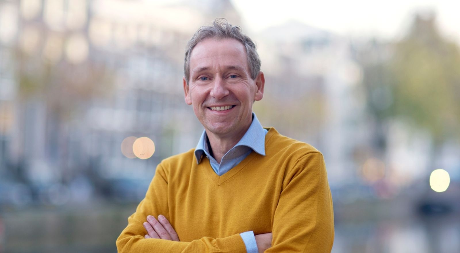 man met armen over elkaar die de kracht van een holistische visie uitstraalt